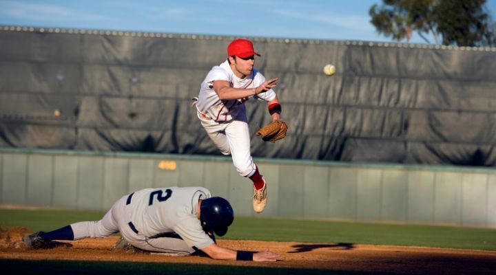 A baseman jumps to catch the baseball